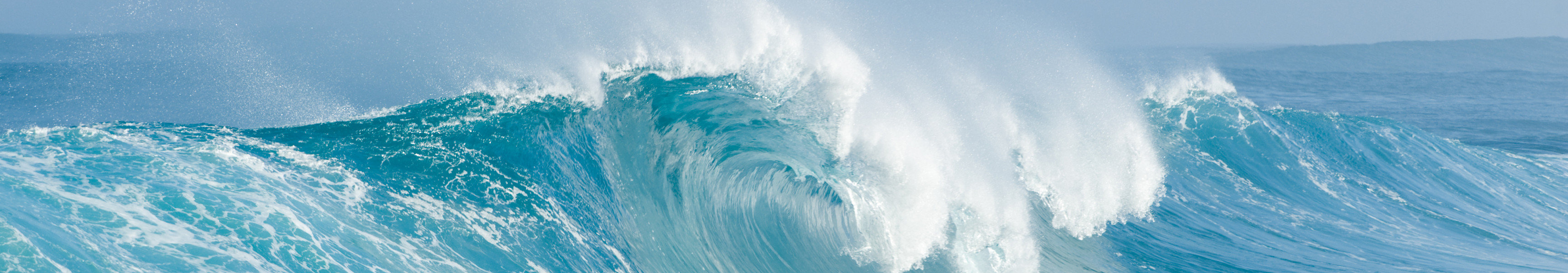 Gro&szlig;e Welle bricht im eisblauen Meer
