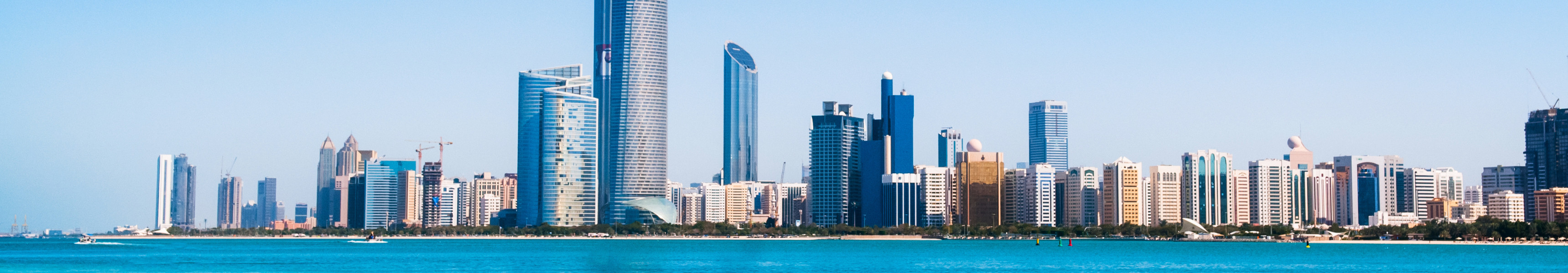 Strand mit t&uuml;rkisblauem Wasser vor der modernen Skyline von Abu Dhabi, Vereinigte Arabische Emirate