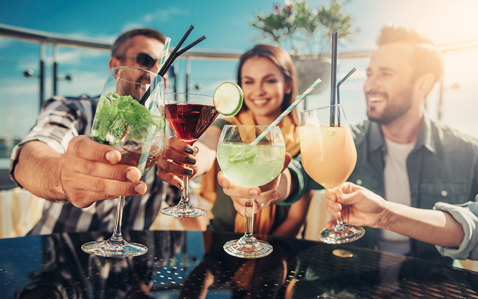 Freunde stoßen mit Cocktails an