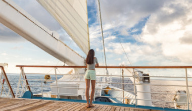 Frau an Deck eines Kreuzfahrtschiffes